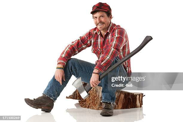 happy lumberjack sitting on a log with an axe - lumberjack stock pictures, royalty-free photos & images