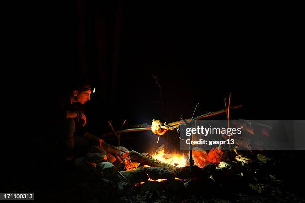 man grilling chicken outdoors - boy scout camping stock pictures, royalty-free photos & images
