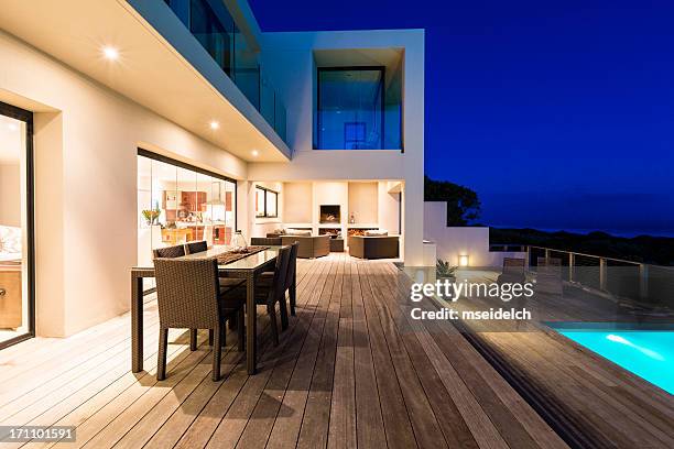 luxury villa pool deck at dusk - illuminated house stock pictures, royalty-free photos & images