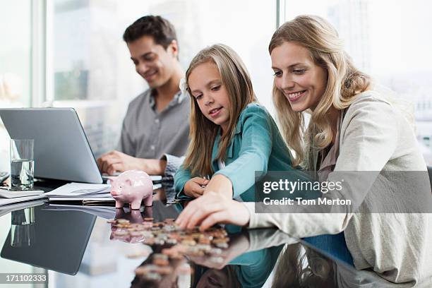 mother and daughter counting coins - mother protecting from rain stockfoto's en -beelden