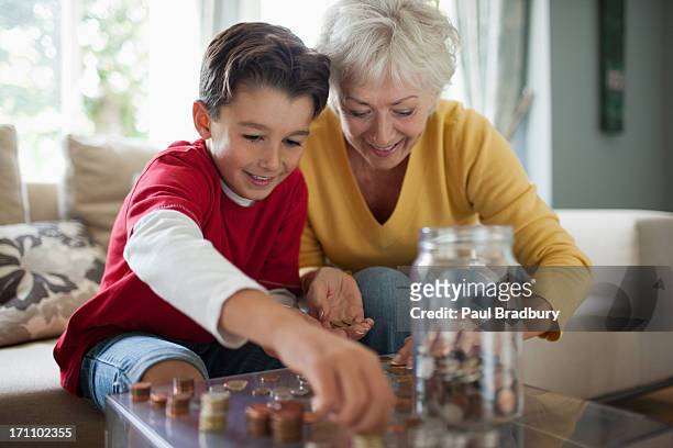 großmutter und enkel zählen münzen - geld stock-fotos und bilder