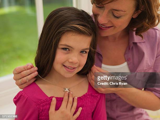 madre aiutando sua figlia fissare collana - collana foto e immagini stock