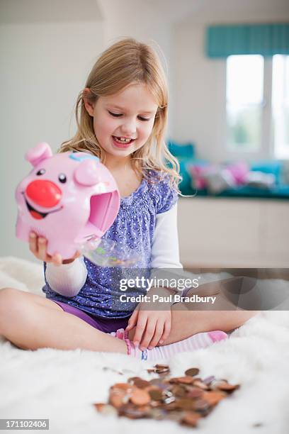 grinning girl with piggy bank - 6 year old blonde girl stock pictures, royalty-free photos & images