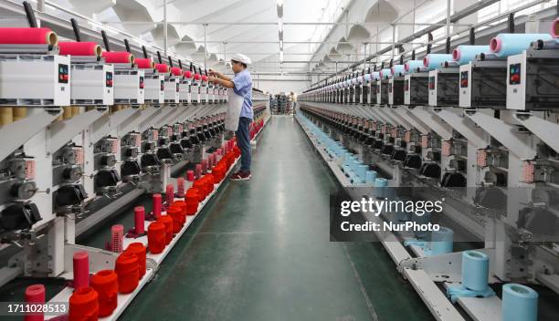 Textile worker spins yarn in a workshop in Huai 'an City, Jiangsu Province, China, Oct. 7, 2023.