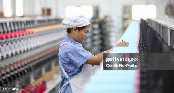 Textile worker spins yarn in a workshop in Huai 'an City, Jiangsu Province, China, Oct. 7, 2023.