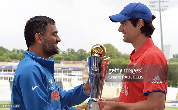 Indian captain Mahendra Sing Dhoni and England captain Alistair Cook pose for photographs with the ICC Champions Trophy at Edgbaston in Birmingham,...