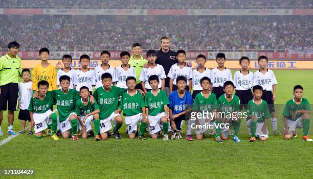 David Beckham plays football with children at half-time during the Chinese Super League match between Hangzhou Greentown and Beijing Guoan at Yellow...