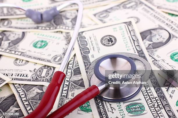 stethoscope on various monetary denominations - planned giving stock pictures, royalty-free photos & images