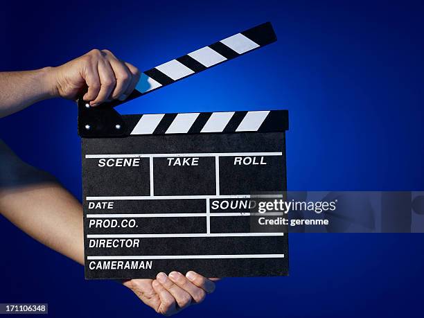 hombre que agarra un clapper - claqueta de cine fotografías e imágenes de stock