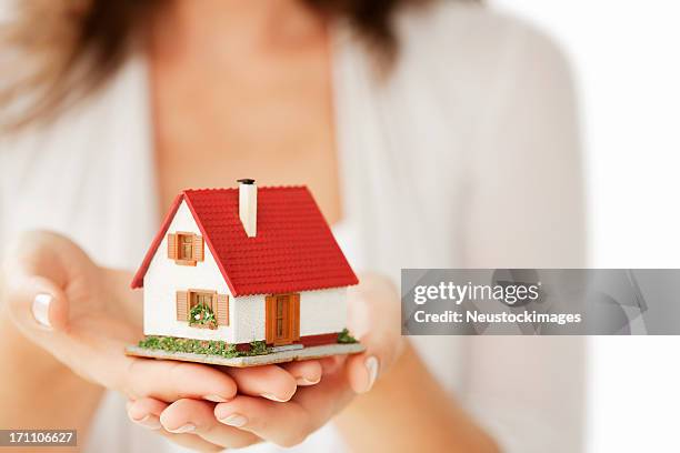 woman's hands holding a little house - isolated - planned giving stock pictures, royalty-free photos & images
