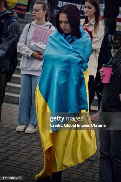 Girl wrapped in the Ukrainian flag stands near a spontaneous memorial to fallen Ukrainian soldiers on October 1, 2023 in Kyiv, Ukraine. Ukraine...