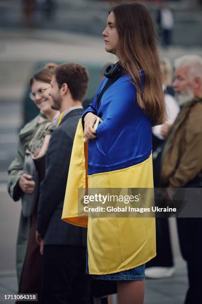 Girl wrapped in the Ukrainian flag stands near a spontaneous memorial to fallen Ukrainian soldiers on October 1, 2023 in Kyiv, Ukraine. Ukraine...