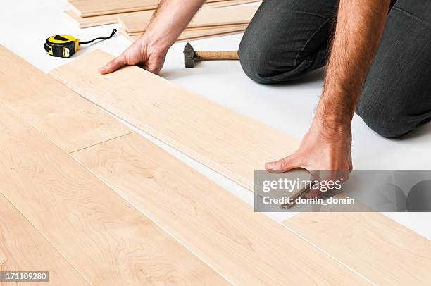 close-up do homem colocando painéis de piso de madeira-de-lei, floorboards - instalando - fotografias e filmes do acervo