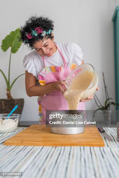 woman pouring cake mixture into baking tin - cake batter stock pictures, royalty-free photos & images