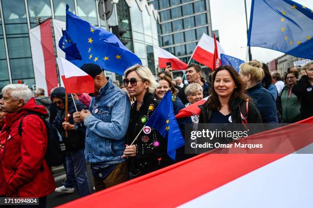 Thousands of people hold Polish and EU flags as Donald Tusk, the leader of Civic Coalition delivers a speech during the March of a million Hearts on...