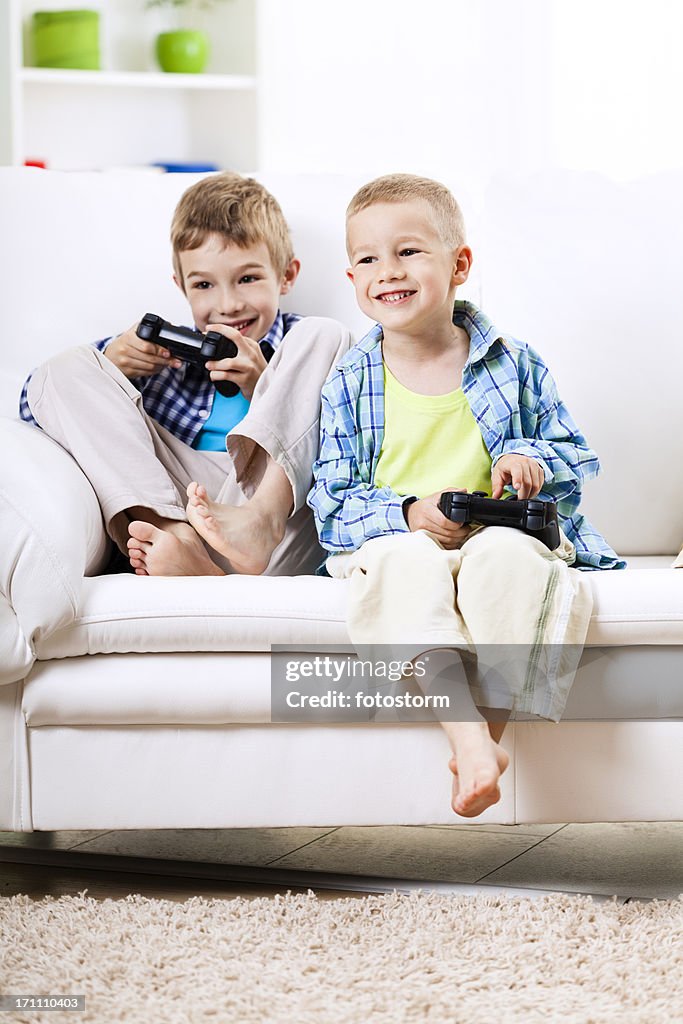 Children with game controllers, playing video games