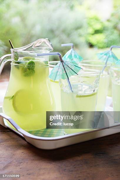 limonade trinken cocktail mit sonnenschirm straws im garten - henkelkrug stock-fotos und bilder