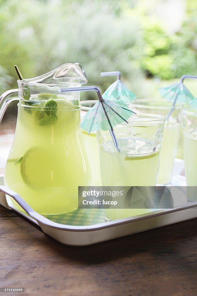 Lemonade cocktail with umbrella drinking straws at garden