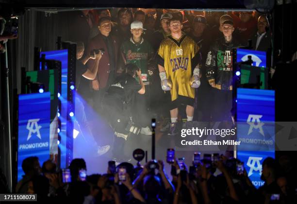 Canelo Alvarez , flanked by rappers Tornillo Vazquez and Santa Fe Klan , waits to enter the ring for his super middleweight title fight against...