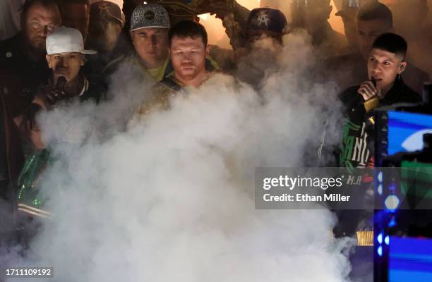 Canelo Alvarez , flanked by rappers Tornillo Vazquez and Santa Fe Klan , blows on smoke as he waits to enter the ring for his super middleweight...