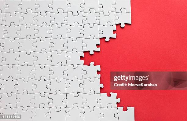 white jigsaw puzzle on a red background - legpuzzel stockfoto's en -beelden