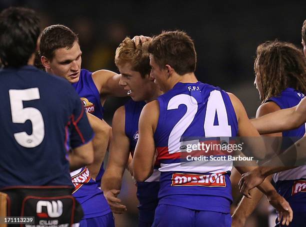 Lachie Hunter of the Bulldogs is congratulated by his teammmates after kicking his first goal during the round 13 AFL match between the Western...