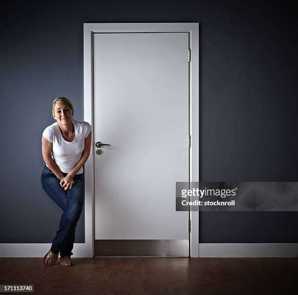 woman waiting outside ladies toilet - cross legged 個照片及圖片檔