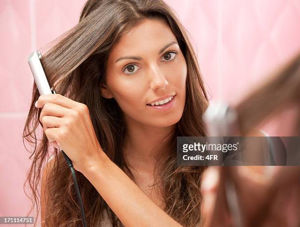 natural beauty straightening her long hair - flat iron stock pictures, royalty-free photos & images