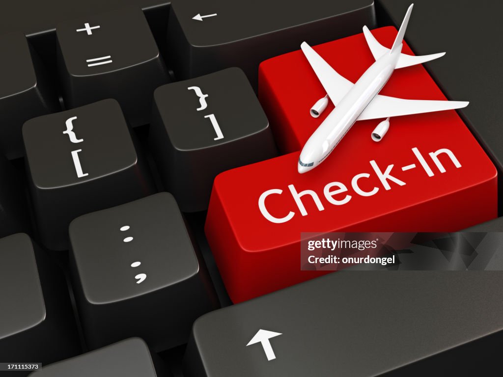 Computer keyboard with red check in key with airplane on