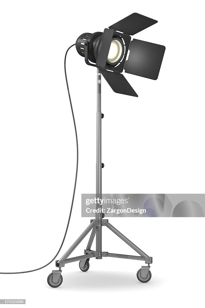 Illuminated studio light on wheels on white background