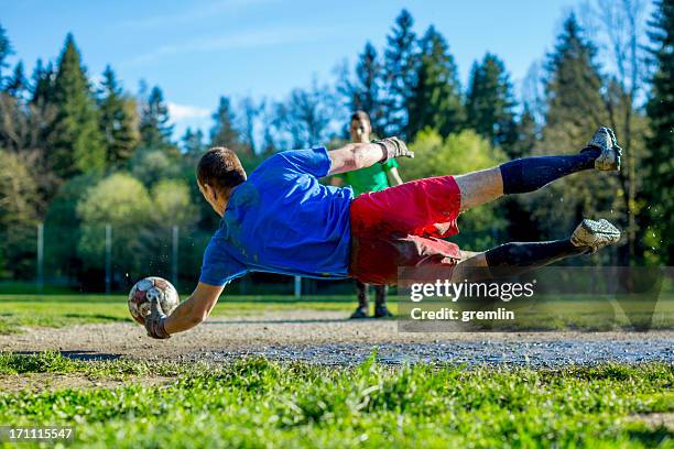 goalkeeper saving the net - muddy football pitch stock pictures, royalty-free photos & images