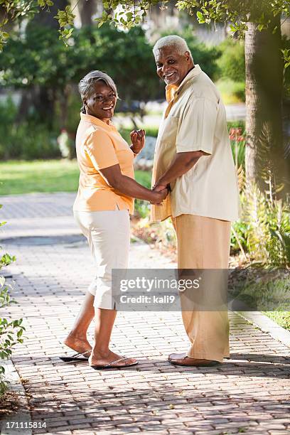 senior african american couple holding hands - brick pathway stock pictures, royalty-free photos & images