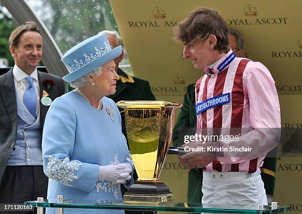 Queen Elizabeth II smiles as she presents Diamond Jubilee Stakes trophy to jockey Adam Kirby after he won riding Lethal Force during day five of...