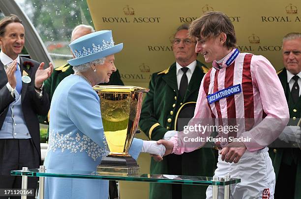 Queen Elizabeth II smiles as she presents Diamond Jubilee Stakes trophy to jockey Adam Kirby after he won riding Lethal Force during day five of...