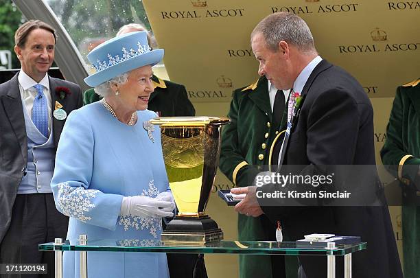 Queen Elizabeth II smiles as she presents Diamond Jubilee Stakes trophy to trainer Clive Cox after he won riding Lethal Force during day five of...