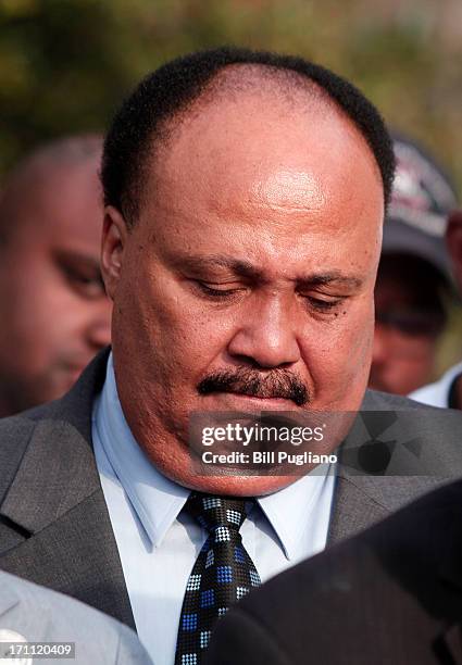 Martin Luther King III bows his head during a prayer at a press conference before marching in the 50th Anniversary Commemorative Freedom Walk June...