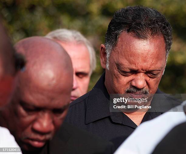 Rev. Jesse Jackson bows his head as a prayer is said at a press conference before marching in the 50th Anniversary Commemorative Freedom Walk June...