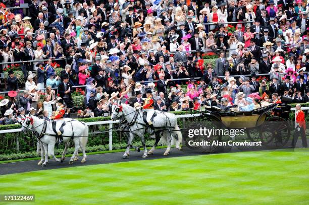 Racegoers wave at Queen Elizabeth II, Prince El Hassan Bin Talal, Princess Sarvath El Hassan and John Warren as they arrive with the Royal Procession...