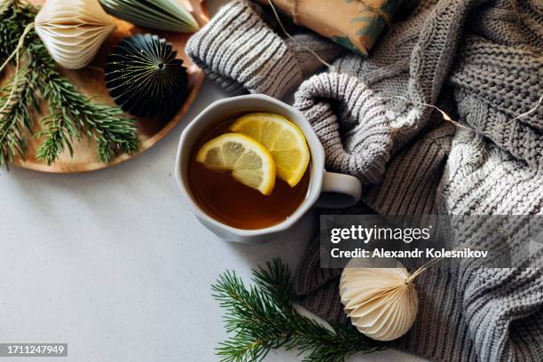 winter still life. citrus tea mug, fir tree branches, warm knitted blanket. hygge lifestyle, cozy winter mood. flat lay with copy space - herpes labial - fotografias e filmes do acervo