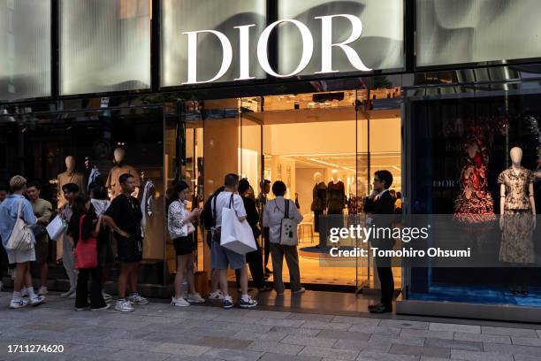 Shoppers including Chinese tourists wait in line outside a store in the Ginza district during the China's National Day holiday on October 01, 2023 in...