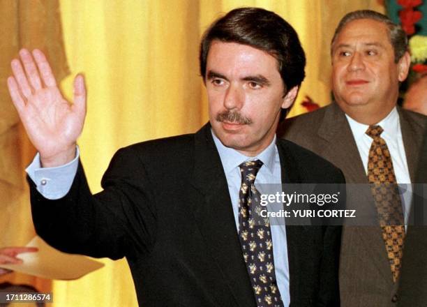 Spanish Prime Minister Jose Maria Aznar waves farewell to reporters as Salvadoran President Armando Calderon Sol looks on 14 November following a...