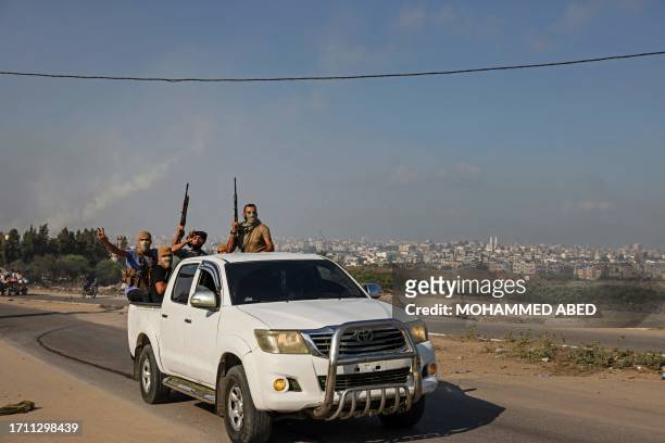 Palestinian militants of the Ezzedine al-Qassam Brigades move towards the Erez crossing between Israel and the northern Gaza Strip on October 7,...