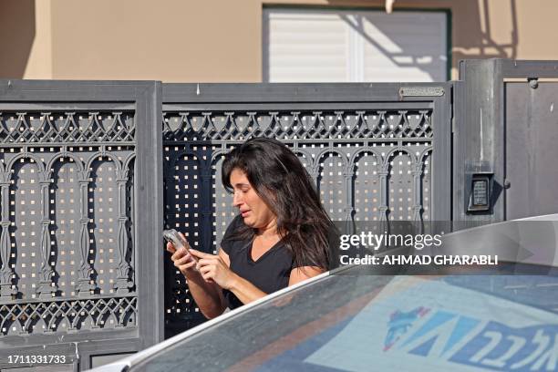 Woman cries as she uses her smart phone during a rocket attack from the Gaza Strip on the southern Israeli city of Ashkelon on October 7, 2023....