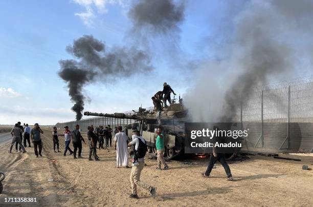 Smoke rises after Palestinian members of the Ezz Al-Din Al Qassam Brigades, the military wing of Hamas burn military armored vehicle belonging to...