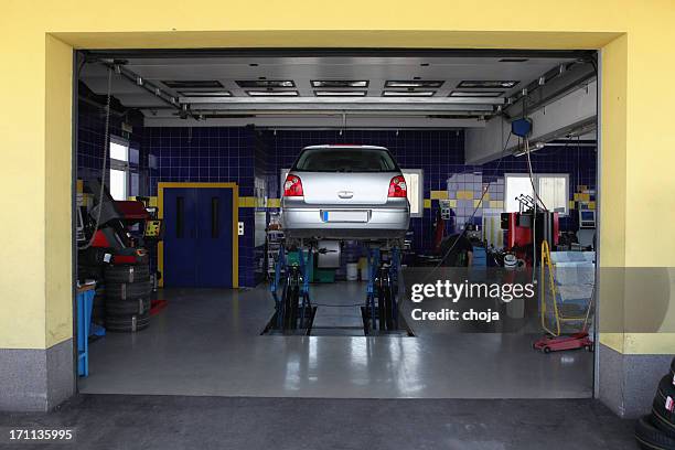 in auto repair shop....changing tires before winter - reparatiewerkplaats stockfoto's en -beelden