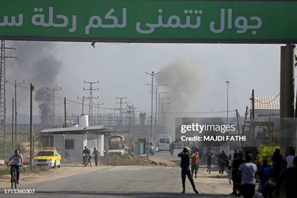 Palestinians and militants from the Ezzedine al-Qassam Brigades run towards the Erez crossing between Israel and the northern Gaza Strip on October...