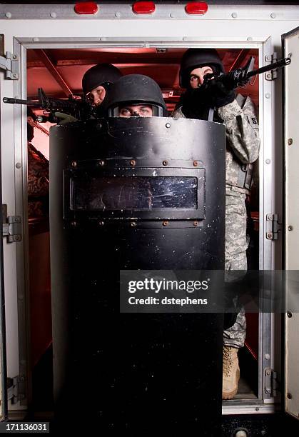 swat team exiting - police in riot gear stockfoto's en -beelden