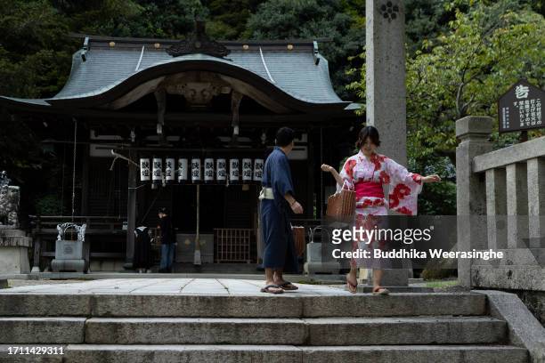 Young couple dressed in Yukata robes, leave the Shinto shrine after worship, at Kinosaki Hot Spring Resort Town on October 01, 2023 in Toyooka, Japan.