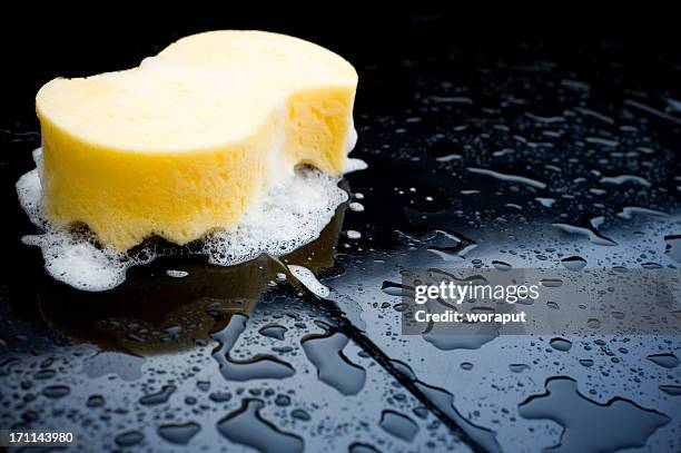 detail of a sponge over a black car during a car wash - foam stock pictures, royalty-free photos & images