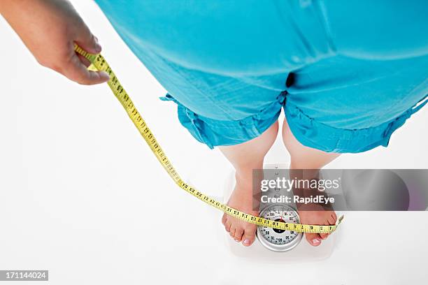 view down overweight torso with tape measure to scales - woman measuring tape stock pictures, royalty-free photos & images